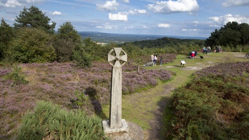 The Celtic Cross and visitors on Gibbet Hill, with a view to the north, at Hindhead Common, Surrey.